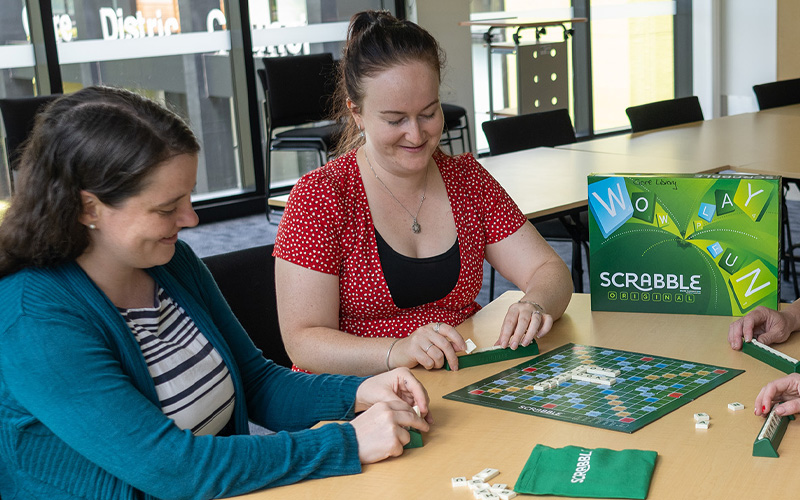 two woman play scrabbble