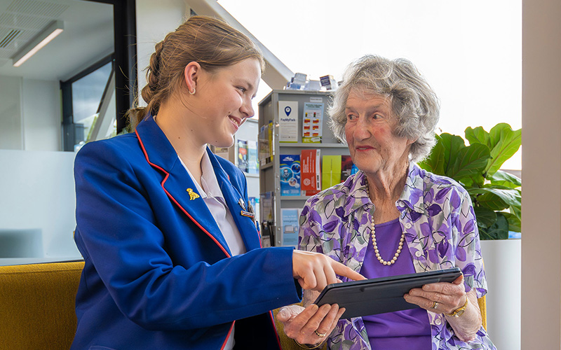 Teenager helps elderly woman with her ipad