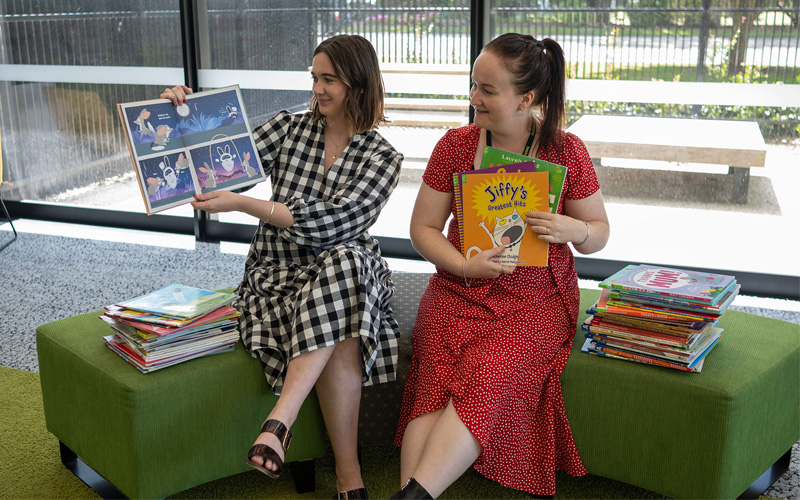Two woman reading aloud